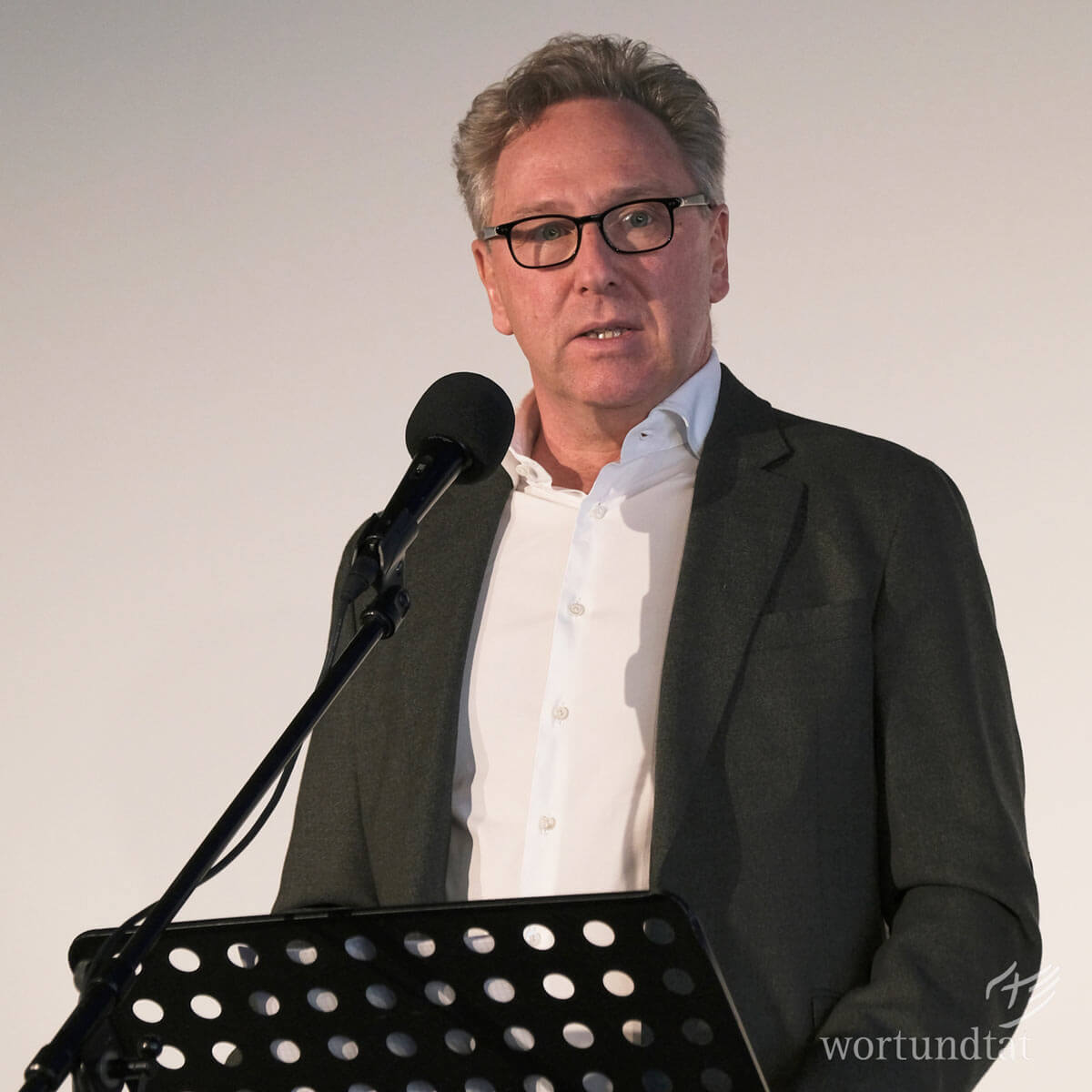 Heinrich Deichmann: "Faith begins with God's love. And we don't want to keep that love to ourselves. We want to pass it on in words and deeds". Man at lectern