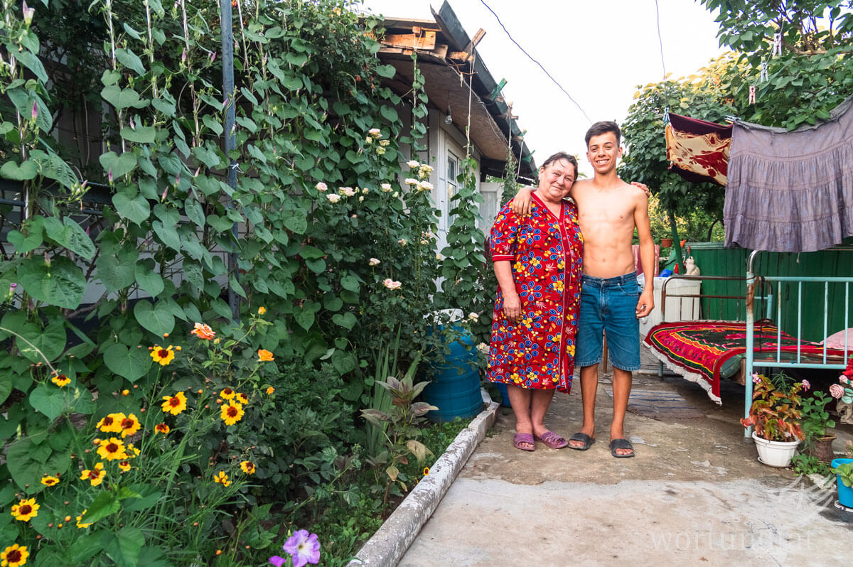 Boy and grandma standing arm in arm in a garden