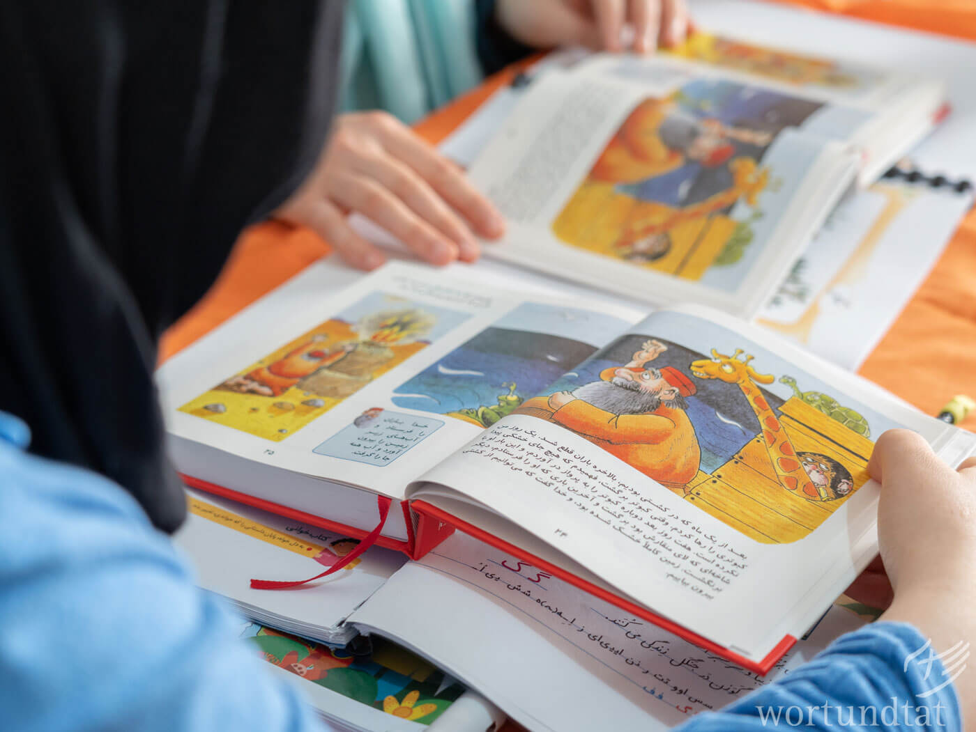 Book with text and pictures, woman bending over it and reading