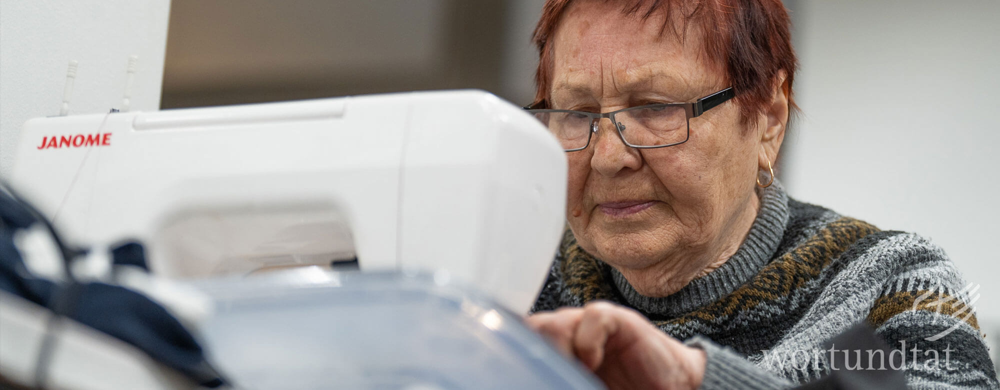 alte Frau an Nähmaschine